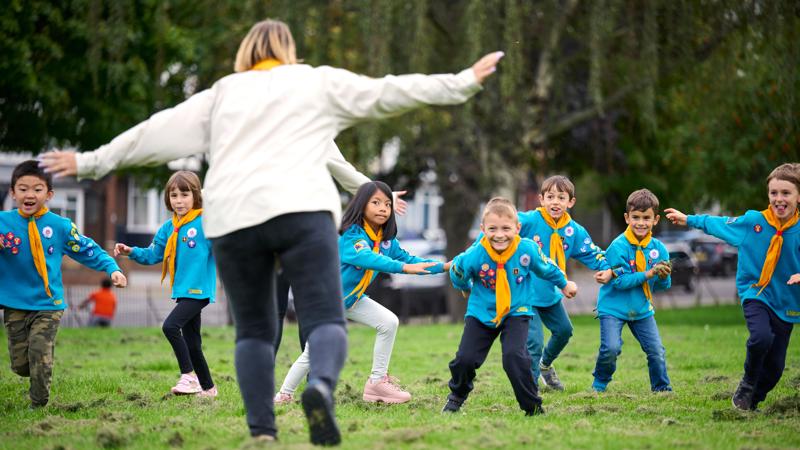 Beavers playing in park with volunteer